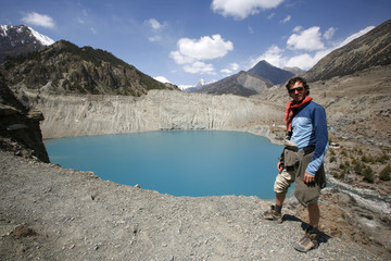 Fototapeta premium man standing on the edge of cliff overlooking blue mountain