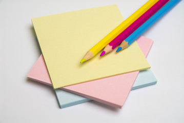 Note paper and coloured pencils isolated on white