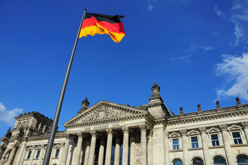 Fototapeta na wymiar Reichstag - parlament niemiecki z flagą Niemiec.