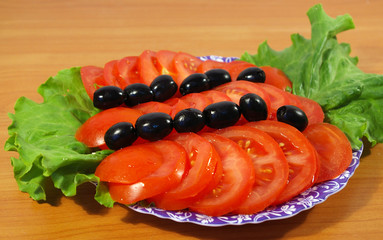 Tomatoes leaves of salad and olives