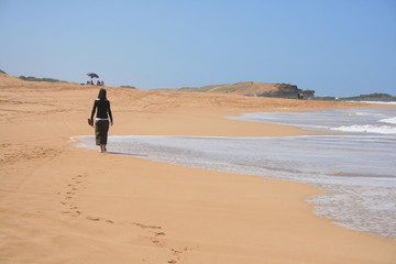 Fototapeta na wymiar Femme marchant sur la plage