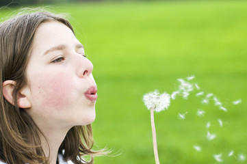 Teenager blowing dandelion