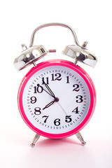 A pink alarm clock on a white background
