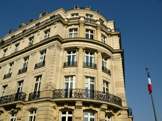 Fototapeta na wymiar Paryski budynek z kamienia, błękitne niebo. Francja.