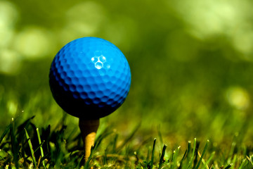 Blue golf ball on wooden tee Focus on ball saturated colors.