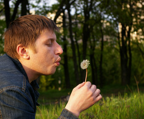 Man blowing dandelion