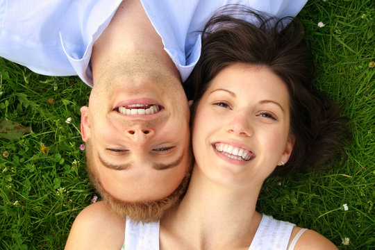 young and happy couple smiling on a meadow