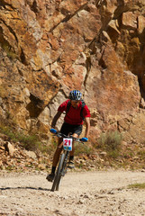 Mountain biker racing near rocks