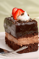 Chocolate mousse cake with cut strawberries and whipped cream