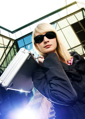 Beautiful young woman with silver case near the modern office 