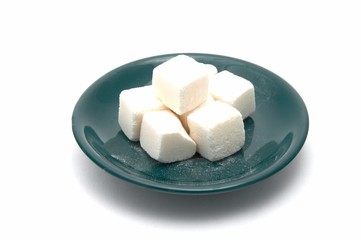 Green plate with slices of sugar