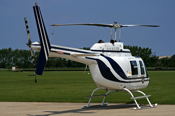 side of grounded white helicopter at airport
