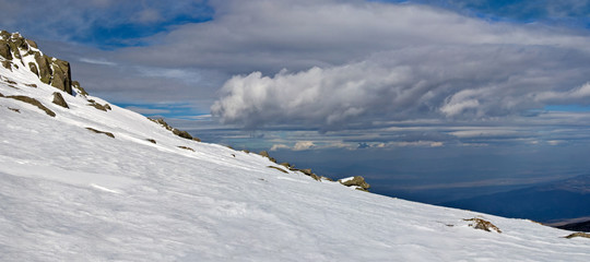 Snowy white mountain slope with blue sky panorama