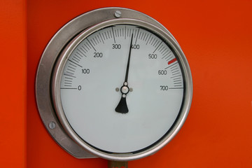 A guage reading 380 on a orange background