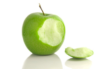 Green apple with bite taken out, on white
