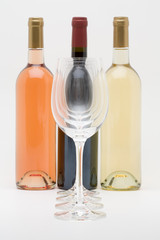 red white and rose wine bottles with glasses in front