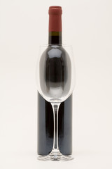 red wine bottle with empty glass in front