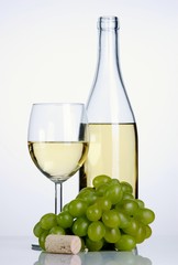 Bottle and glass of white wine with grapes and cork