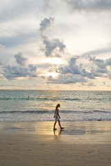Fototapeta na wymiar girl walking along.the beach
