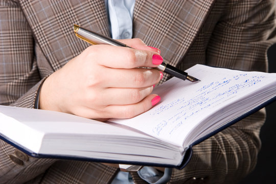 Businesswoman hand with pen and notebook