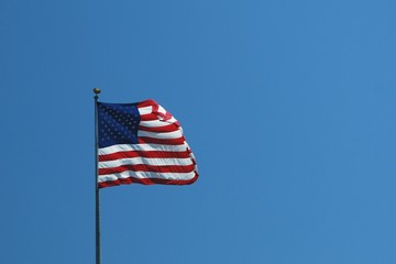 US flag fying against blue sky