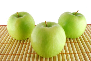 Three green apples on the table-cloth