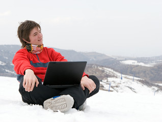 Happy teens student with laptop in winter mountains Tien Shan
