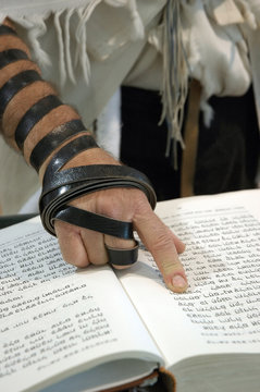 Jewish man and prayer book with phylacteries and talit