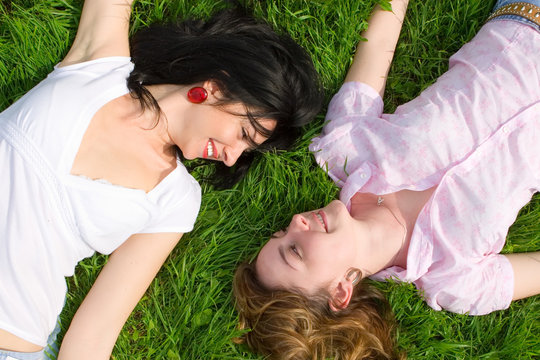 Smiling Women Rest On The Green Grass