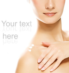 Young beautiful woman applying moisturizer to her skin 