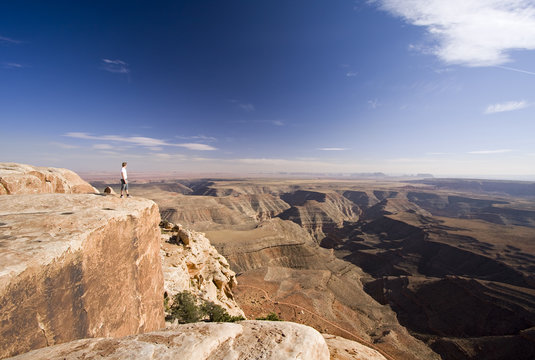 man standing on cliff edge at Muley Point, Utah
