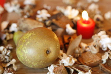 Fototapeta na wymiar Pear,dried plants and burning candle