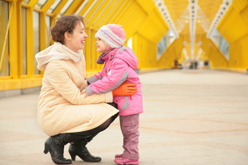 mother and daughter look each other on footbridge