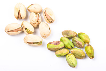 Several pistachio nuts naked and in shell close up isolated