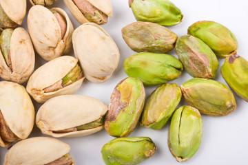 Several pistachio nuts naked and in shell close up