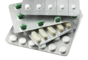 Stack of Various Foil Packaged Pills on White