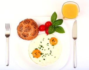 Breakfast with fried eggs, tomatoes and orange juice isolated