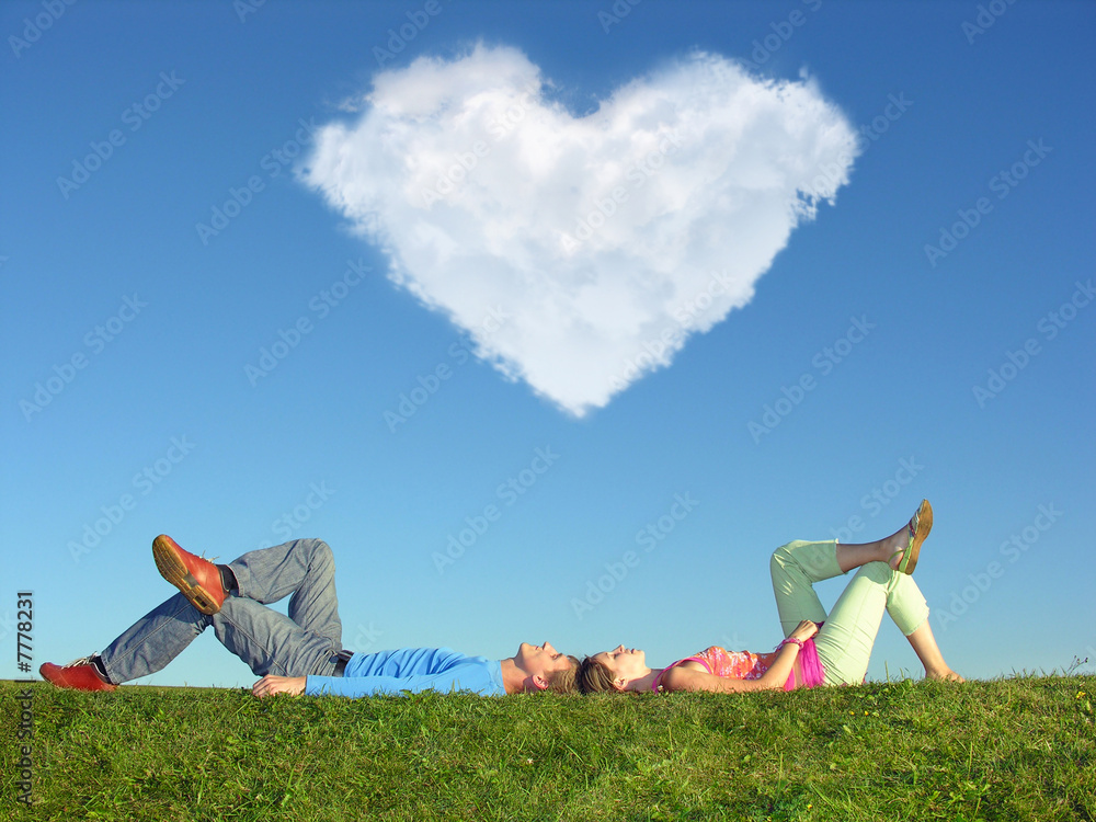 Wall mural young pair lays on grass, In sky cloud in form of heart