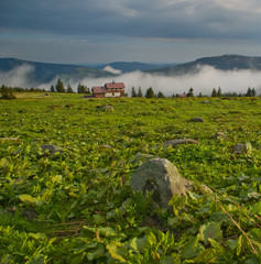 Spring mountain landscape after rain with fog and mysterious sky