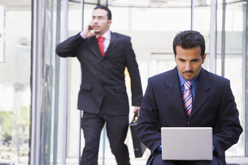 Businessman working at laptop outside