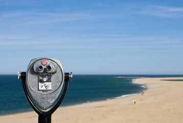 Coin operated binoculars for beach observation, blue sky and oce