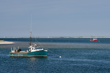 Old green and red fishing boats anchored in calm water