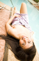 Naklejka premium Beautiful Girl Laying On Side Of Pool