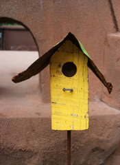 Cheerful Yellow Wooden Birdhouse in Backyard Garden