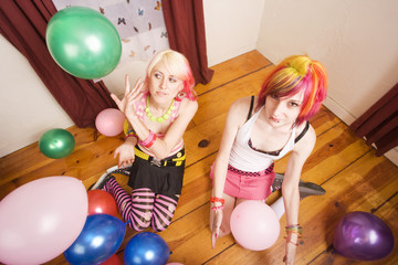 Two girls in a room with colorful balloons