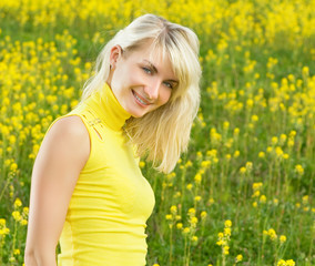 Naklejka na ściany i meble Beautiful young woman in a flower field