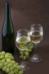 Weisser Wein mit Flasche, Gläser und Trauben