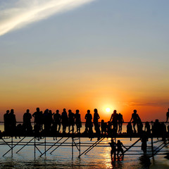 Fototapeta na wymiar young people meeting sunset on sky background