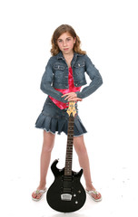 Cute girl wearing denim and leaning on a black electric guitar.