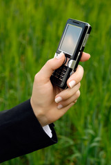 The hand of the business woman holds a mobile phone